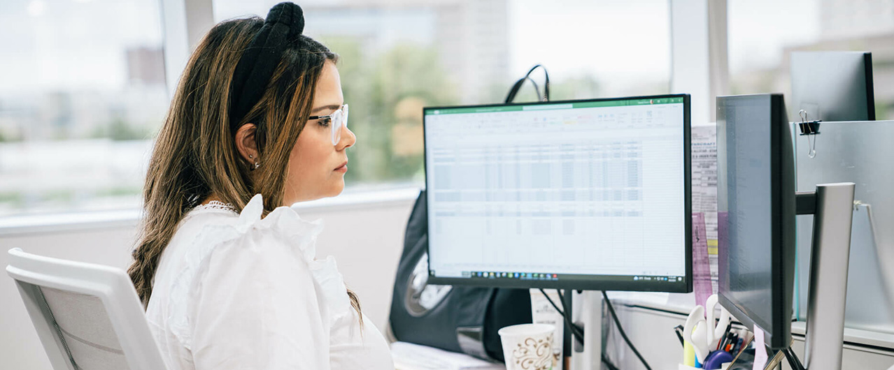 woman at a desk working on a spreadsheet
