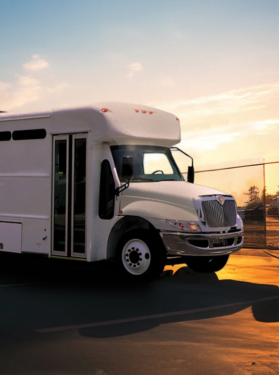White shuttle bus parked next to a security fence at a prison near Chicago